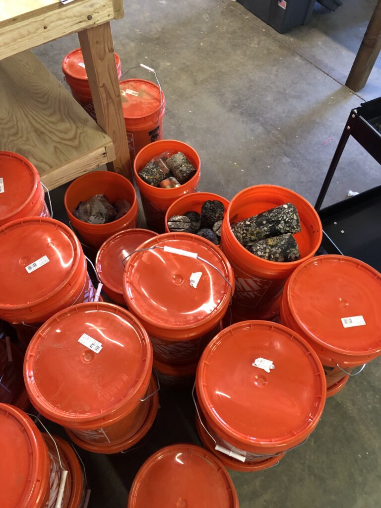 Dozens of Home Depot 5-gallon buckets filled with soil samples ready for testing